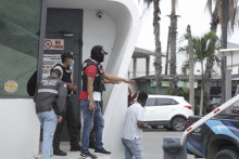 Policajti zasahujú po tom, čo skupina maskovaných ozbrojených mužov vtrhla do štúdia ekvádorskej verejnoprávnej televízie v najväčšom ekvádorskom meste Guayaquil v utorok 9. januára 2024. FOTO: TASR/AP