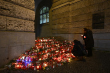 Ľudia prinášajú kvety a sviečky pred budovu Filozofickej fakulty Univerzity Karlovej po streľbe v centre Prahy. FOTO: TASR/AP