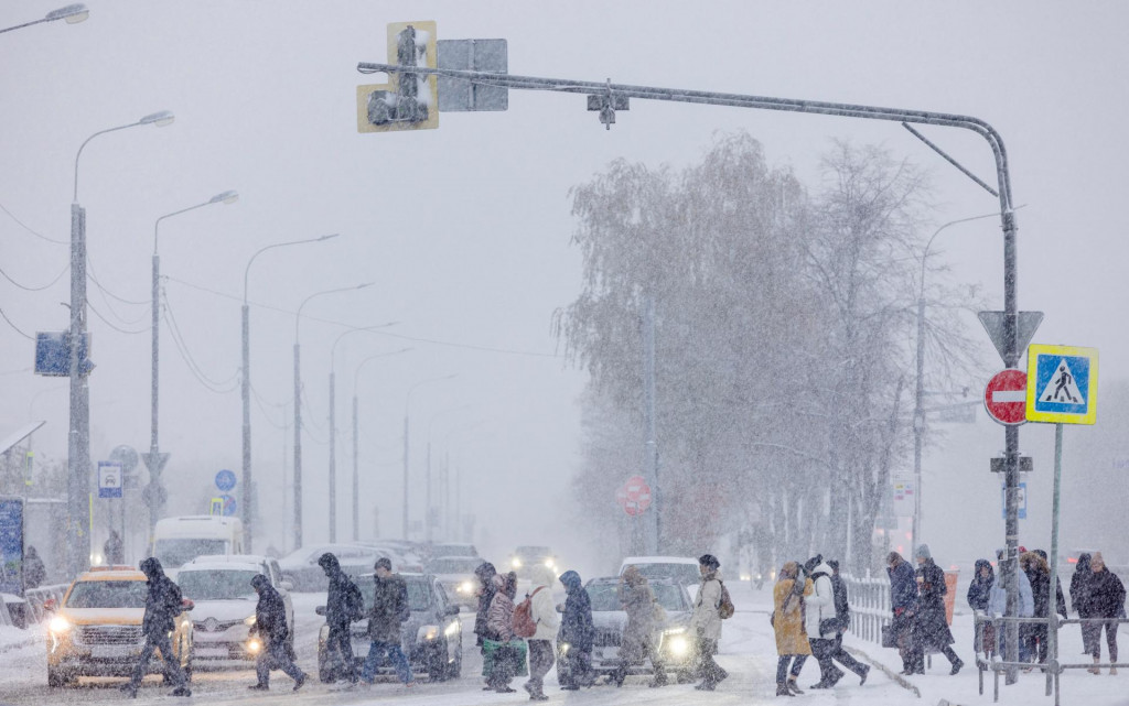 Ľudia prechádzajú cez ulicu v Moskve počas sneženia. FOTO: Reuters