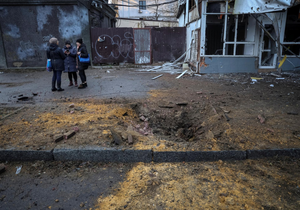 Miestni obyvatelia stoja na mieste ruského vojenského útoku. FOTO: Reuters