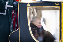 Dánska kráľovná Margaréta II., ktorú sprevádzajú príslušníci dánskeho husárskeho pluku, máva zo zlatého koča počas jazdy ulicami Kodane. FOTO: TASR/AP
