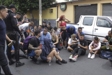 Evakuovaní zamestnanci sedia na chodníku po tom, čo v utorok 9. 1. skupina maskovaných ozbrojených mužov vtrhla do štúdia ekvádorskej verejnoprávnej televízie. FOTO: TASR/AP