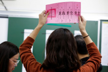 Volebný pracovník drží hlasovací lístok vo volebnej miestnosti počas prezidentských a parlamentných volieb v meste New Taipei na Taiwane. FOTO: Reuters