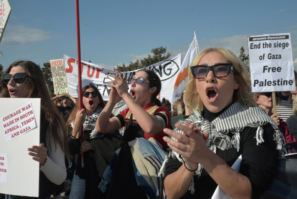 Ľavicoví aktivisti kričia heslá počas protestu pred bránami britskej základne. FOTO: Reuters