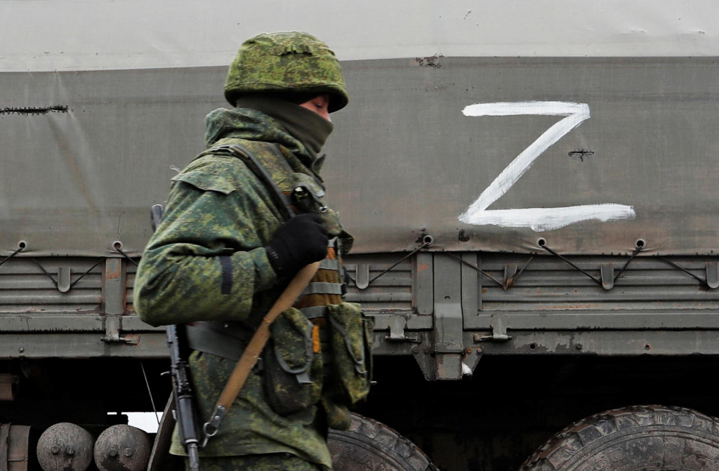 Vojaci proruskej milície kráčajú k vojenskému konvoju ozbrojených síl separatistickej samozvanej Luhanskej ľudovej republiky na ceste v Luhanskej oblasti, Ukrajina 27. februára 2022. FOTO: Reuters