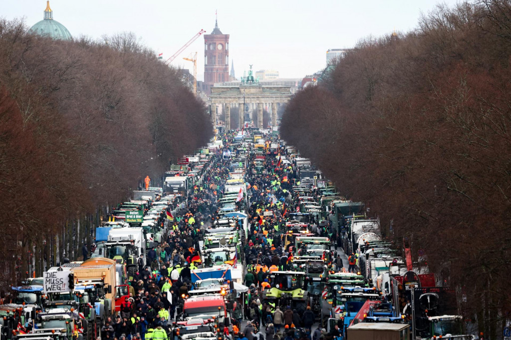 Nemeckí farmári protestujú proti zníženiu dotácií na daň z vozidiel nemeckej koaličnej vlády neďaleko Brandenburskej brány v Berlíne. FOTO: Reuters