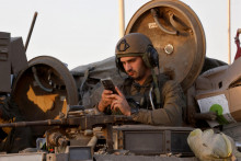 Izraelský vojak pozerá do mobilu. FOTO: Reuters