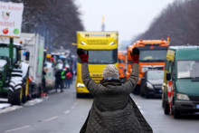 Demonštrant ukazuje na prichádzajúci kamión, zatiaľ čo nemeckí kamionisti protestujú. FOTO: Reuters