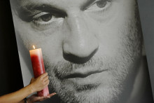 Na archívnej snímke sviečka horí pred portrétom hokejistu Pavla Demitru počas tlačovej konferencie 12. septembra 2011 na zimnom štadióne v Trenčíne. FOTO: TASR/Radovan Stoklasa
