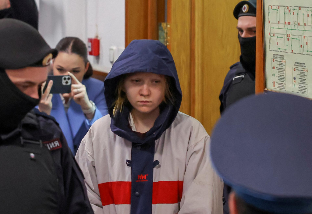 Darja Trepová, ktorá je podozrivá zo zabitia ruského vojenského blogera Maxima Fomina, všeobecne známeho pod menom Vladlen Tatarsky, je eskortovaná do budovy súdu pred pojednávaním v Moskve. FOTO: Reuters