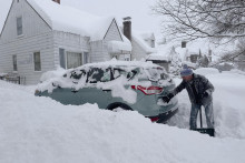 Muž odhrabáva sneh zo svojho auta a cesty po nočnom snežení v Buffale, americkom štáte New York. FOTO: TASR/AP