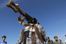 Príslušník kmeňa lojálny Húsíom nesie guľomet počas vojenskej prehliadky. FOTO: Reuters