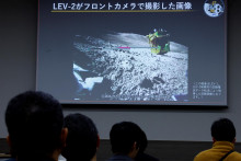 Novinári sa pozerajú na obrazovku so snímkou z roveru LEV-2 na Mesiaci. FOTO: REUTERS