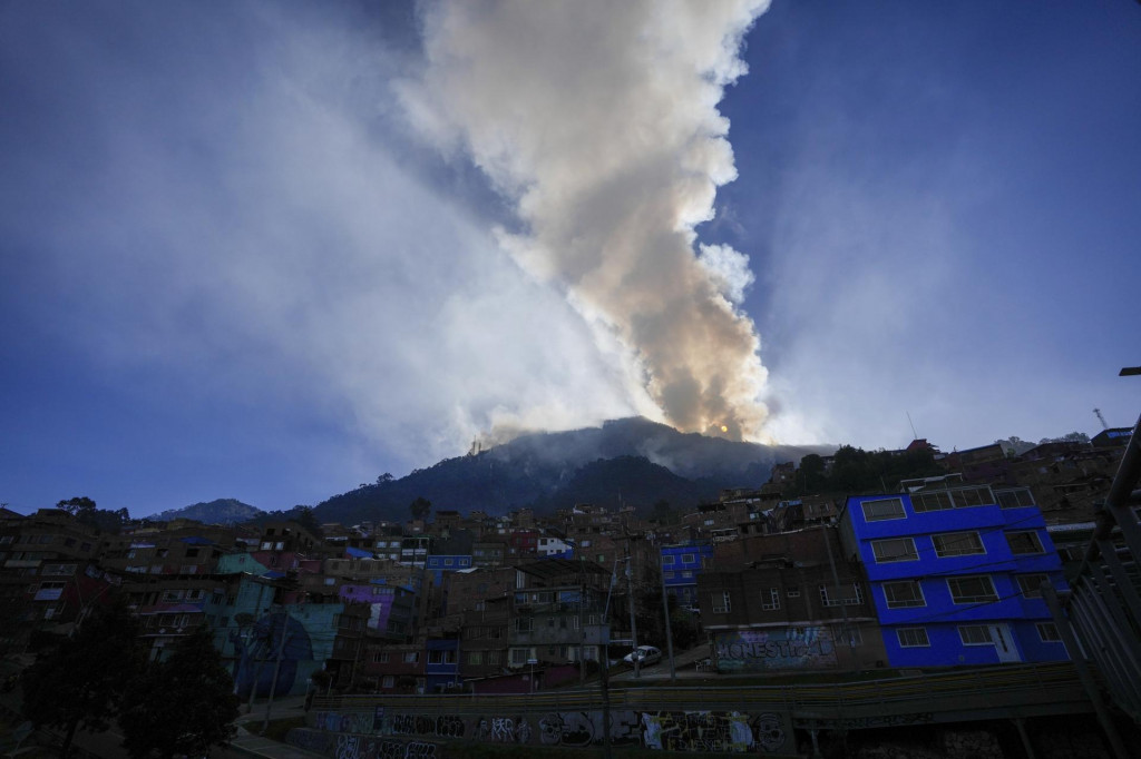 Slnko stúpa počas lesného požiaru na kopci El Cable v kolumbijskej Bogote. FOTO: TASR/AP