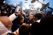 Francúzsky prezident Emmanuel Macron v obkľúčení novinárov. FOTO: Reuters