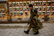 Vojak prechádza okolo steny s fotografiami rukojemníkov unesených počas útoku palestínskej islamistickej skupiny Hamas. FOTO: Reuters