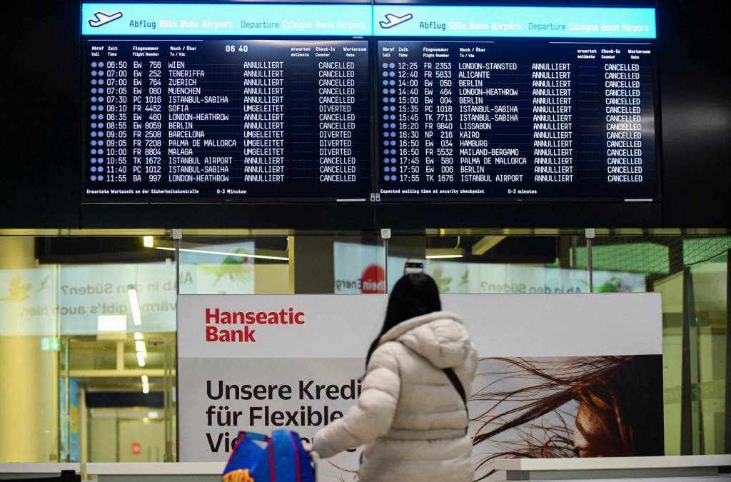 Cestujúci si prezerá zoznam zrušených a odklonených letov na kolínskom letisku Bonn. FOTO: REUTERS