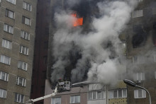 Hasiči hasia požiar, ktorý zachvátil obytnú budovu po útoku ruskej armády v Kyjeve. FOTO: TASR/AP