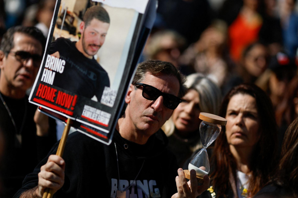 Muž drží transparent vyzývajúci na prepustenie rukojemníka Itaya Chena v izraelskom Tel Avive. FOTO: REUTERS