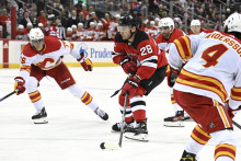 Slovenský hokejista v drese Calgary Flames Martin Pospíšil a hráč New Jersey Devils Timo Meier v zápase zámorskej NHL New Jersey Devils - Calgary Flames v Newarku. FOTO: TASR/AP