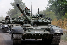 Príslušníci proruských jednotiek riadia tanky pri osade Olenivka v Doneckej oblasti. FOTO: Reuters