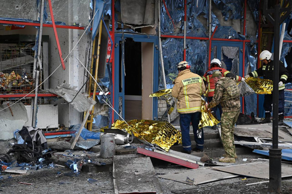 Hasiči pri poškodenej budove v ruskom Belgorode. FOTO: TASR/AP
