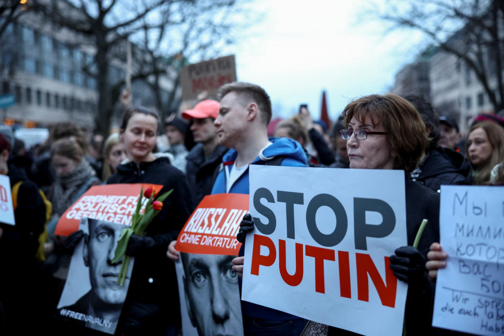 Ľudia držia transparenty, keď sa zúčastňujú na vigílii pred ruským veľvyslanectvom v Berlíne po smrti lídra ruskej opozície Alexeja Navaľného. FOTO: Reuters