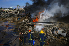 Hasiči sa usilujú uhasiť požiar zničeného skladu po izraelskom leteckom útoku na priemyselnú zónu v prístavnom meste Ghazieh, na juhu Libanonu. FOTO: TASR/AP