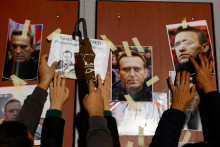 Ľudia vešajú portréty ruského opozičného vodcu Alexeja Navaľného na prednú bránu ruského veľvyslanectva, keď sa zúčastňujú protestu a vigílie v Kappara na Malte. FOTO: Reuters