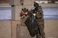 Pracovník mestského úradu na príkaz úradov odstraňuje kvety z pamätníka obetiam politických represií, ktoré priniesli ľudia, aby vzdali úctu Alexejovi Navaľnému v Petrohrade. FOTO: TASR/AP
