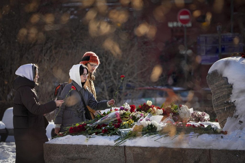 Mládež kladie kvety k pamätníku, veľkému balvanu zo Sloveckých ostrovov, kde bol zriadený prvý gulag pre politických väzňov v Moskve na pamiatku zosnulého ruského opozičného lídra Alexeja Navaľného. FOTO: TASR/AP