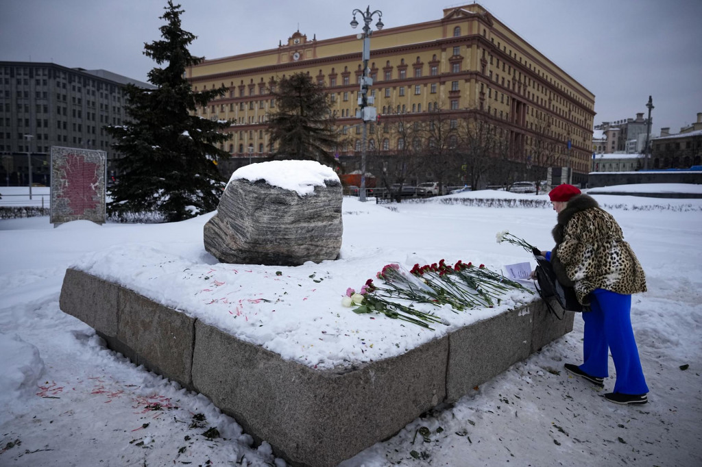 Žena kladie kvety k pamätníku, veľkému balvanu zo Sloveckých ostrovov, kde bol zriadený prvý gulag pre politických väzňov v Moskve na pamiatku zosnulého ruského opozičného lídra Alexeja Navaľného. FOTO: TASR/AP