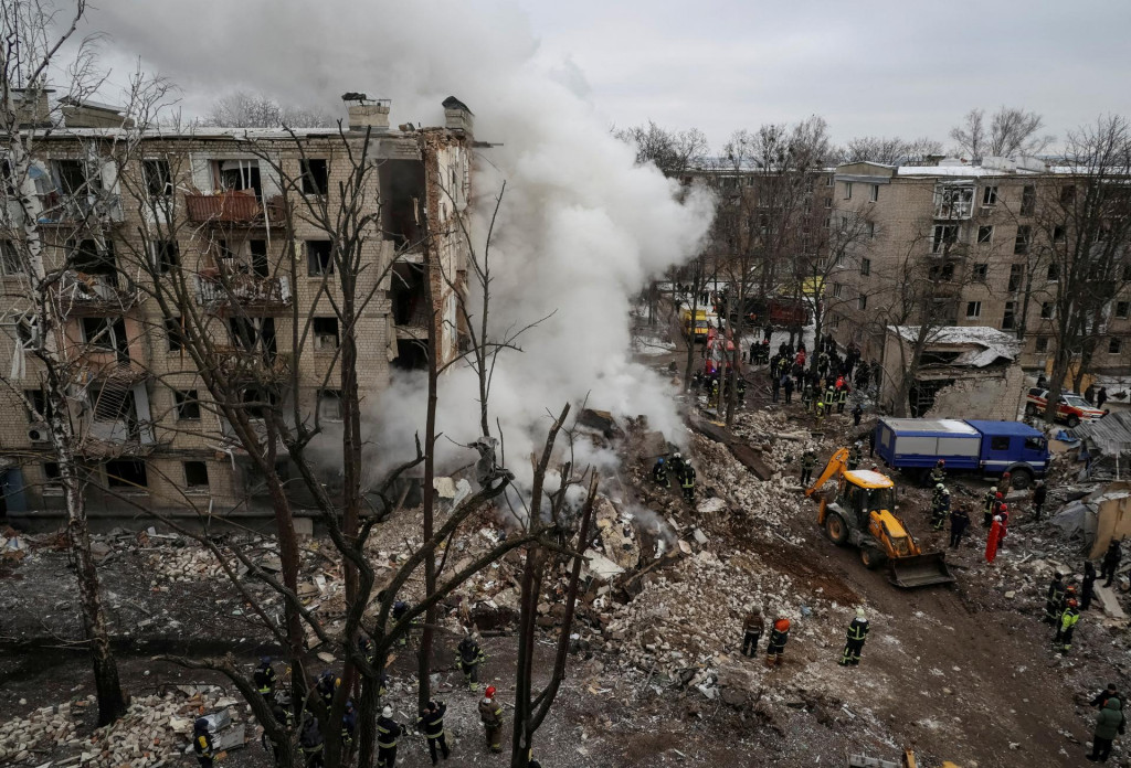 Záchranári pracujú na mieste obytnej budovy ťažko poškodenej počas ruského raketového útoku v Charkove na Ukrajine. FOTO: Reuters