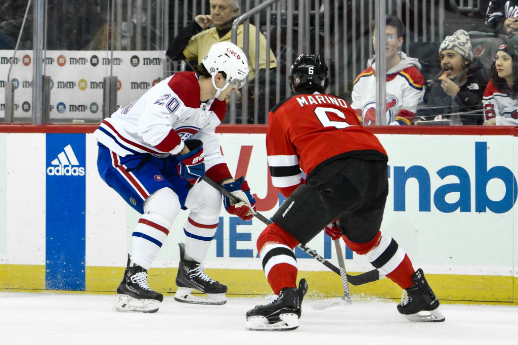 Ľavé krídlo Montrealu Canadiens Juraj Slafkovský (20) kontroluje puk proti obrancovi New Jersey Devils Johnovi Marinovi (6) počas prvej tretiny v Prudential Center. FOTO: Reuters/USA Today