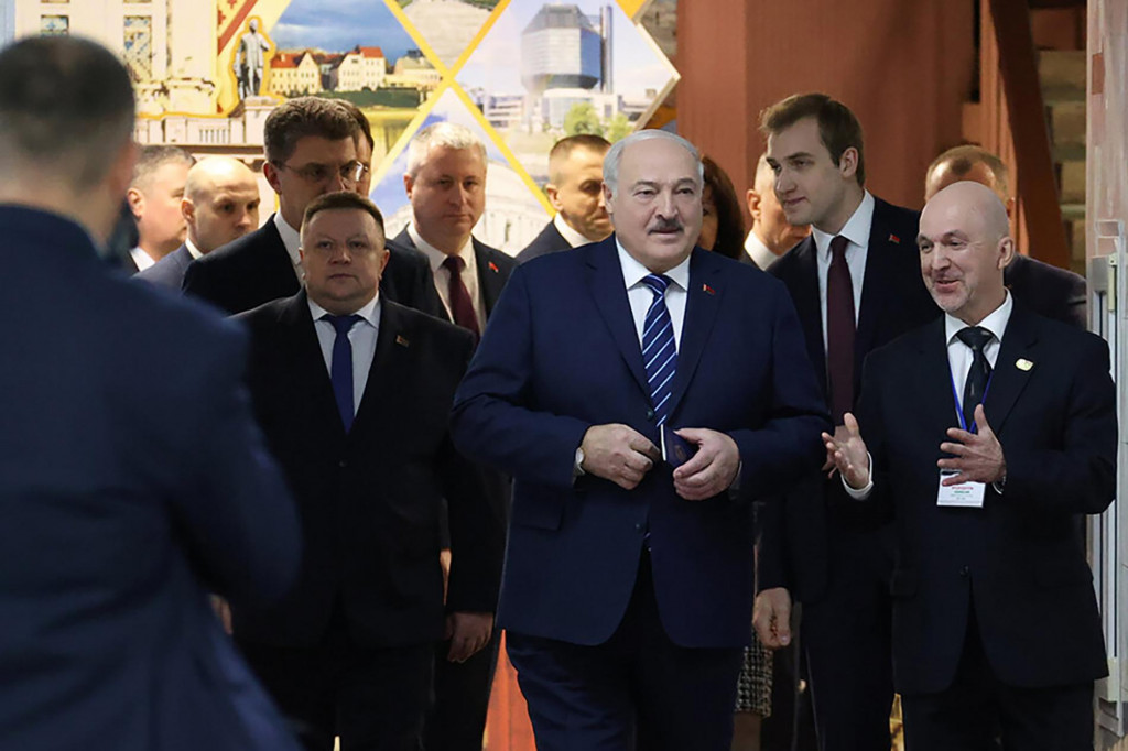 Bieloruský prezident Alexander Lukašenko (uprostred) kráča pred hlasovaním v celoštátnych voľbách vo volebnej miestnosti v Minsku. FOTO: TASR/AP