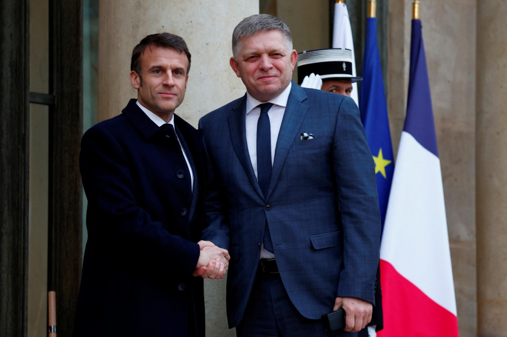 Francúzsky prezident Emmanuel Macron víta slovenského premiéra Roberta Fica pri príchode na konferenciu na podporu Ukrajiny s európskymi lídrami a predstaviteľmi vlády v Elyzejskom paláci. FOTO: Reuters
