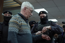 Policajt nasadil putá ruskému veteránovi, bojovníkovi za ľudské práva Olegovi Orlovovi počas súdneho pojednávania v Moskve. FOTO: Reuters