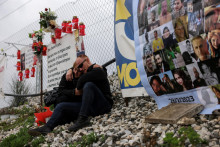 Príbuzní obetí najsmrteľnejšieho vlakového nešťastia v Grécku počas spomienkovej slávnosti pri príležitosti uplynutia roka od nešťastia v Tempi. FOTO: Reuters