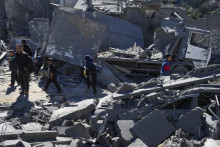 Palestínčania prehľadávajú trosky zničenyých obytných budov po izraelskom leteckom útoku na pásmo Gazy. FOTO: TASR/AP