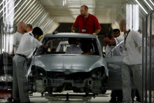Zamestnanci pracujú na montážnej linke v závode Volkswagen. FOTO: Reuters
