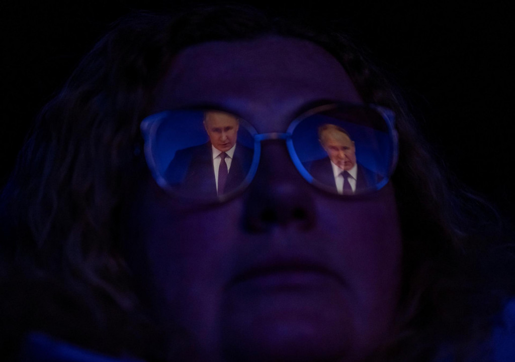 Obyvateľka Petrohradu sleduje v kine televízny prenos výročného prejavu ruského prezidenta Vladimira Putina. FOTO: Reuters