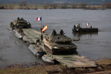 Francúzski vojaci prepravujú španielskych vojakov na tanku Leopard 2Es, keď prekračujú rieku Visla počas cvičenia NATO Dragon-24 v Poľsku. FOTO: Reuters