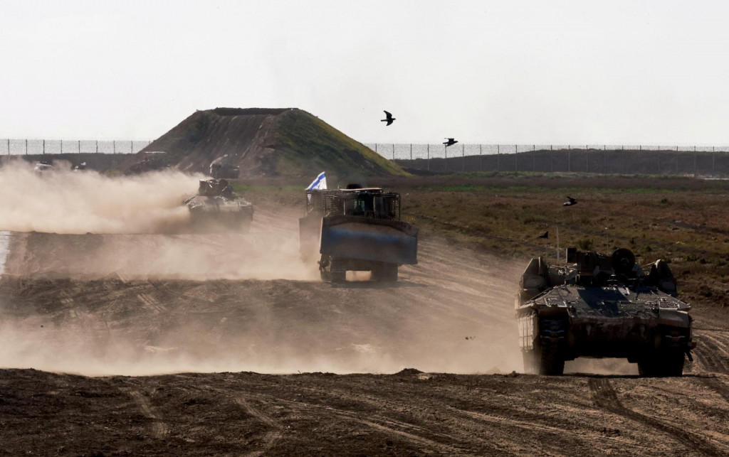 Vojenské vozidlá manévrujú pri hraničnom plote medzi Izraelom a Gazou. FOTO: Reuters