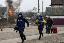 Novinári na Ukrajine, ktorí sa bežia ukryť pred ostreľovaním v Irpine.