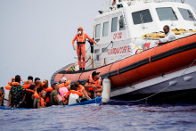 Príslušníci talianskej polície sa pripravujú na nalodenie migrantov neďaleko ostrova Lampedusa v Stredozemnom mori. FOTO: Reuters
