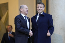 Nemecký kancelár Olaf Scholz, ktorého víta francúzsky prezident Emmanuel Macron pred Elyzejským palácom v Paríži. FOTO: TASR/AP