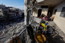 Palestínska žena a dieťa kontrolujú miesto izraelského leteckého útoku na budovu. FOTO: Reuters