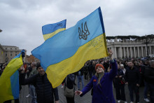 Ľudia mávajú ukrajinskými vlajkami pred tradičnou modlitbou Anjel Pána vo Vatikáne. FOTO TASR/AP