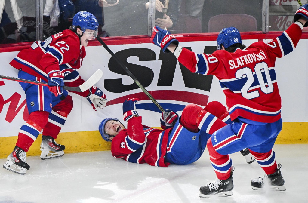 Slovensk&yacute; hokejista v drese Montrealu Canadiens Juraj Slafkovsk&yacute; (vpravo) sa te&scaron;&iacute; z g&oacute;lu, ktor&yacute; strelil jeho spoluhr&aacute;č Mike Matheson (uprostred). FOTO TASR/AP