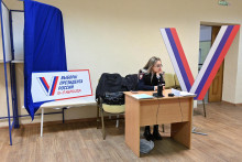 Policajt sedí za stolom vo volebnej miestnosti počas príprav na prezidentské voľby. FOTO: Reuters